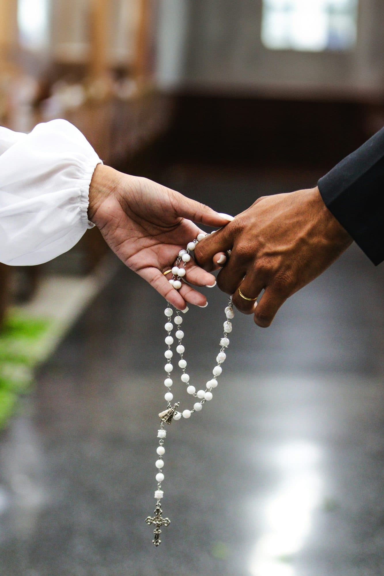A rosary passed from one hand to another